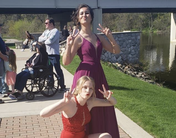 two teenage girls in prom dress posing for photo