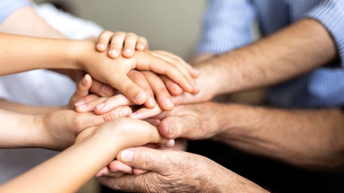 various people putting their hands together