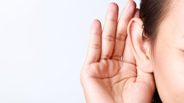 woman holding hand to hear to listen