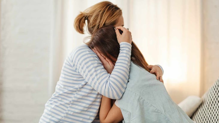 woman hugging sad teenager girl