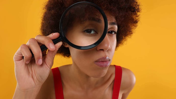 woman looking through a magnifying glass