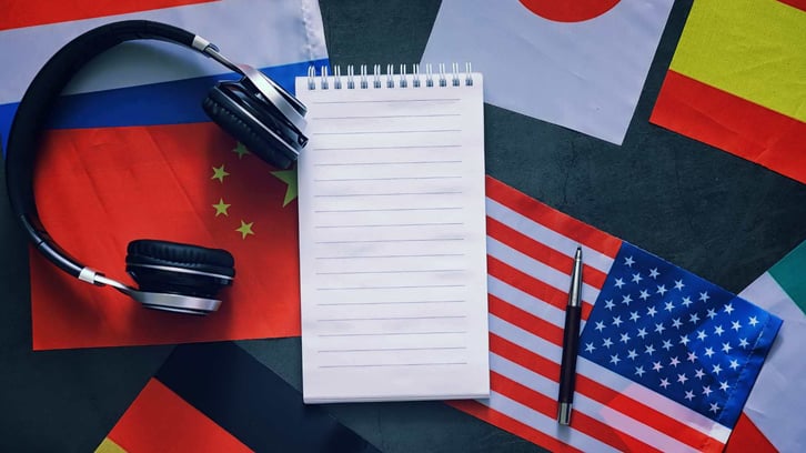 world flags with headphones and a notepad