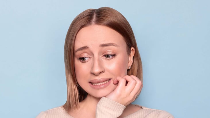 worried teen girl with hand on face