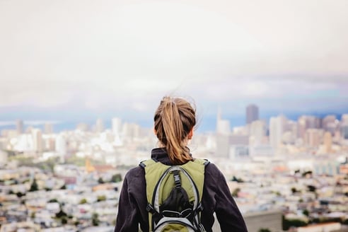 young woman standing alone looking at a city scape