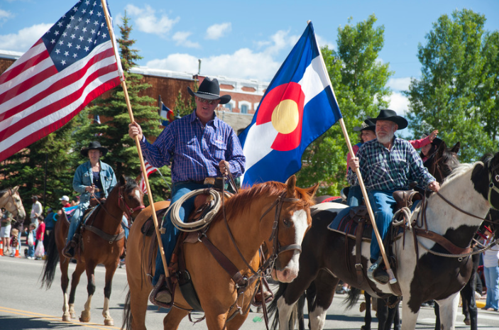 men on horses in parade carrying flags