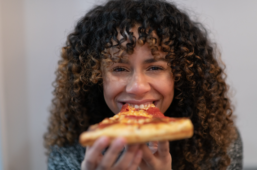 smiling girl eating pizza