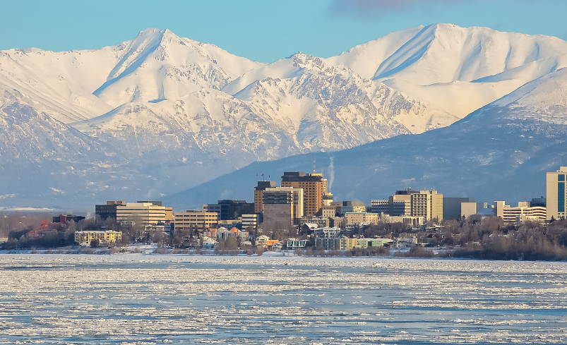 Alaskan city with snow covered mountains behind