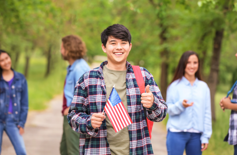 boy holding U.S. flag with thumb up