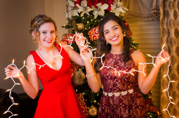 two teen girls holding string of lights