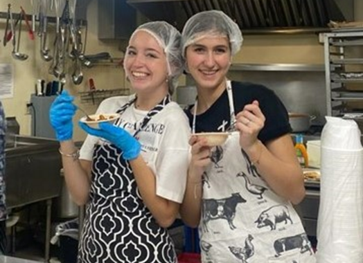 two teen girls cooking in industrial kitchen