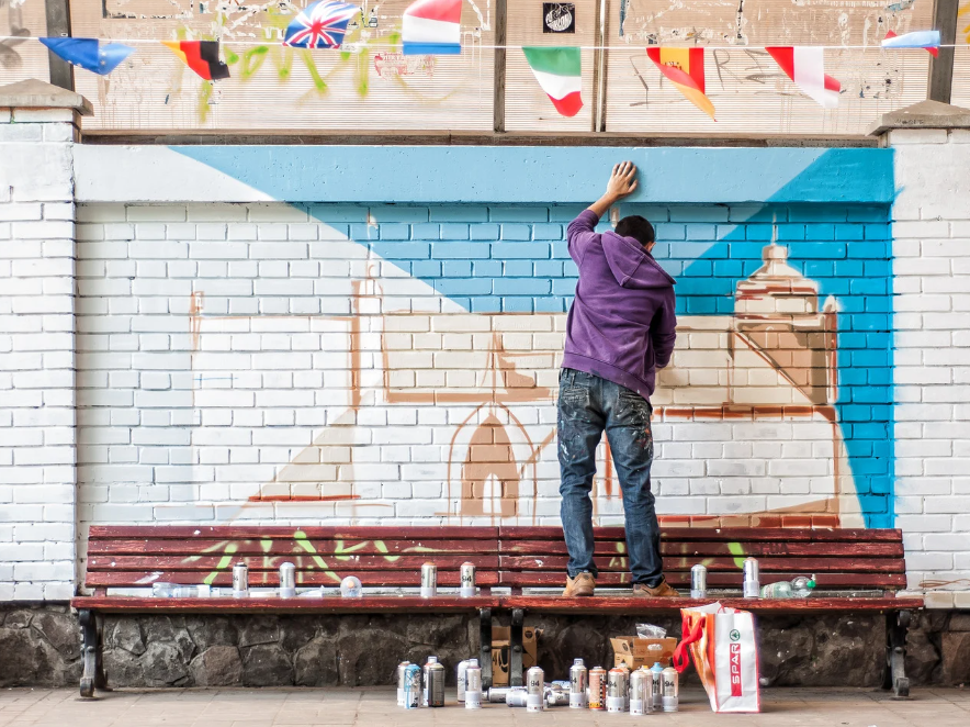 young man painting a wall mural 